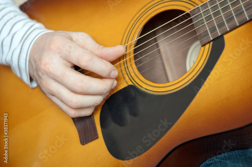 A man plays the six string guitar
