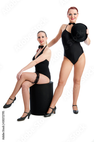 Two female dancers posing against white