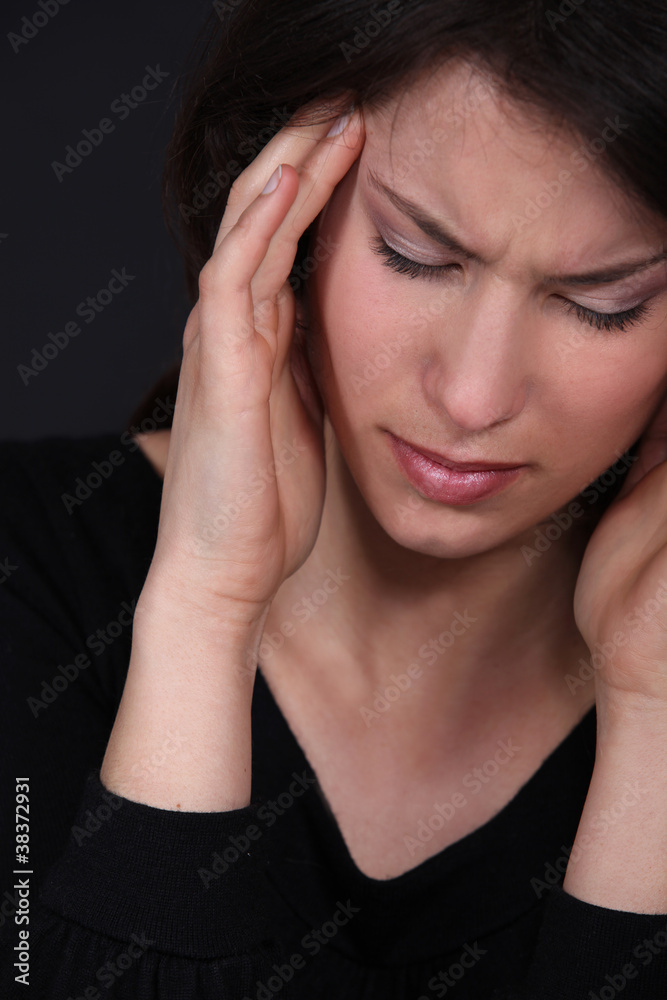 Woman suffering from a throbbing headache Woman suffering from a throbbing headache