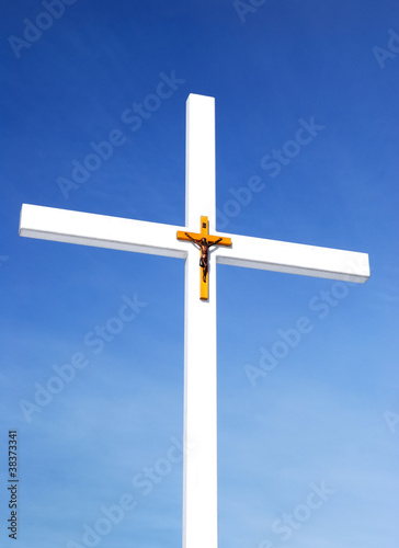 catholic cross with crusifixion sign against blue sky photo