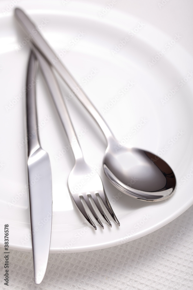 fork, knife, spoon and a white plate