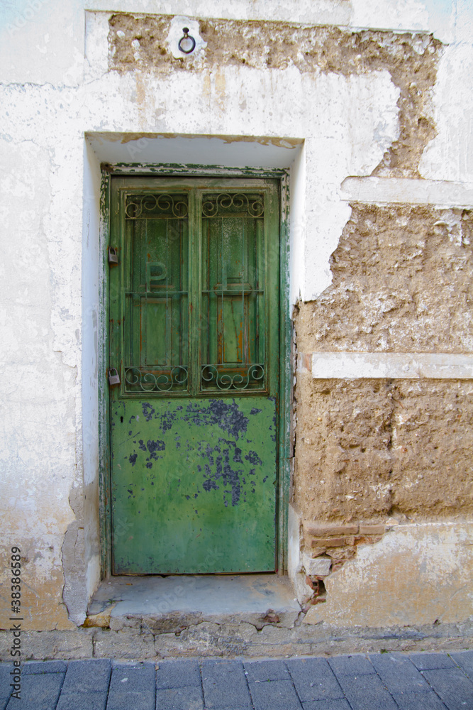 White wall with texture, green wooden door