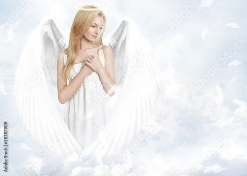Young woman as angel with white wings and aureole