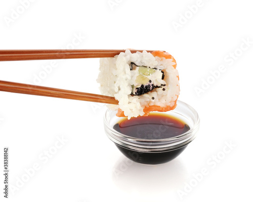 Dipping roll in sauce isolated on white