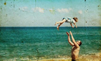father and son on the beach. Photo in old image style.