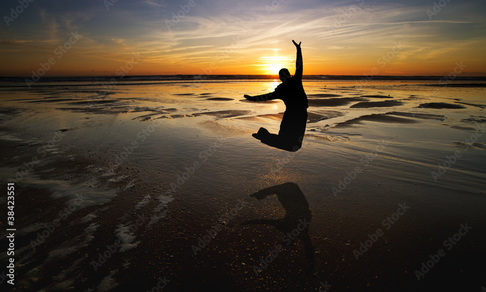 silhouette of girl jumping in sunset at beach