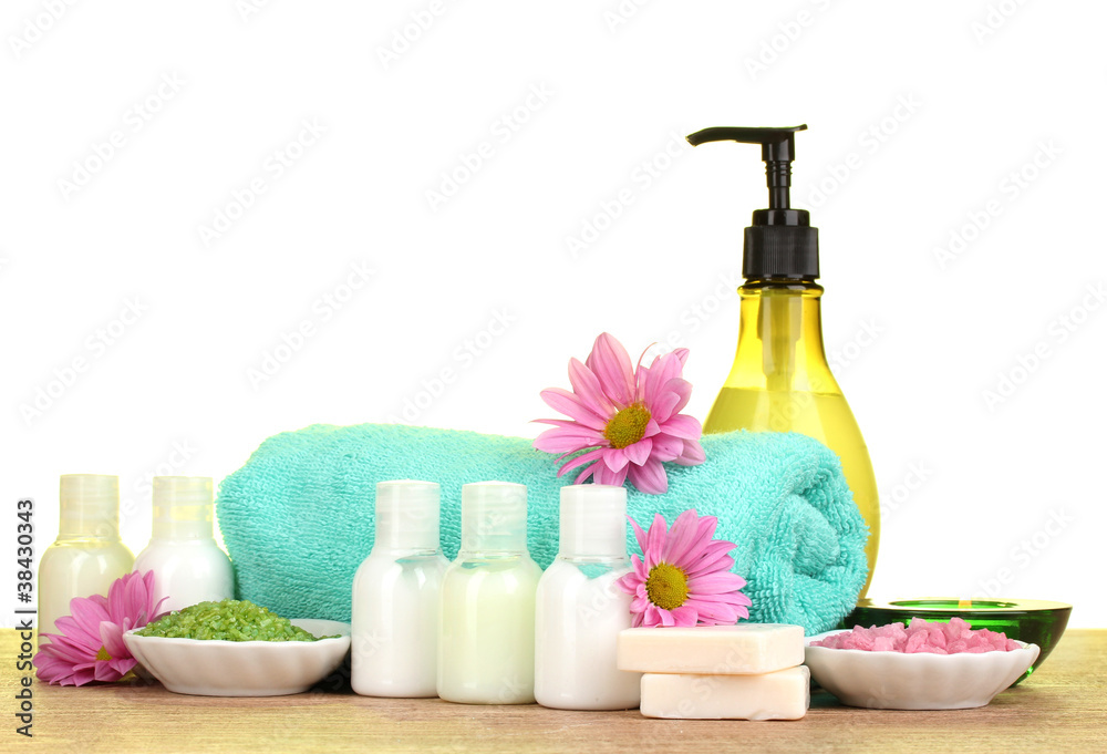 Hotel amenities kit on wooden table on green background