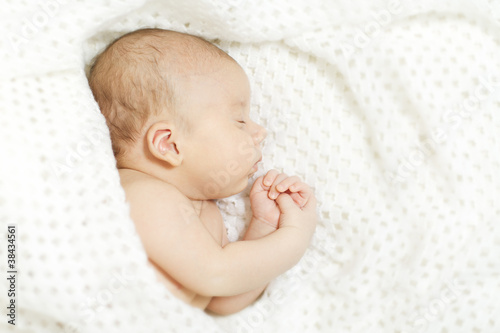 Sleeping baby covered with white blanket
