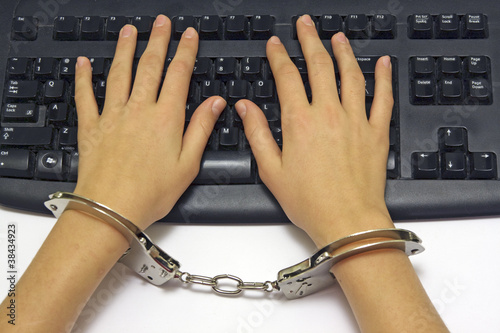 Handcuffed hands on the black keyboard