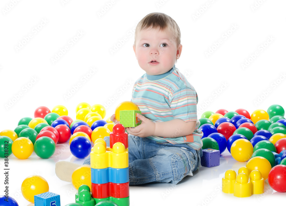 The little boy plays multi-coloured toys The little boy plays multi-coloured toys