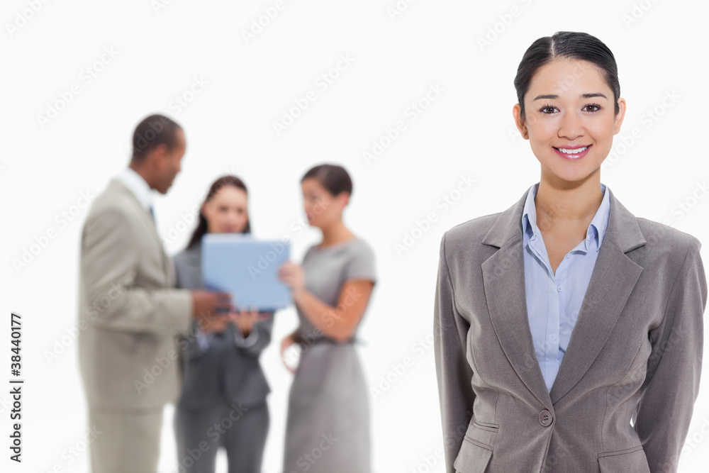 Businesswoman smiling with co-workers in the background Businesswoman smiling with co-workers in the background