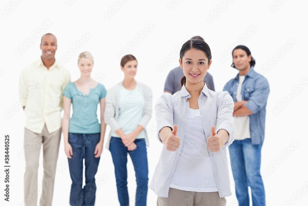 People behind a woman smiling with her thumbs-up People behind a woman smiling with her thumbs-up