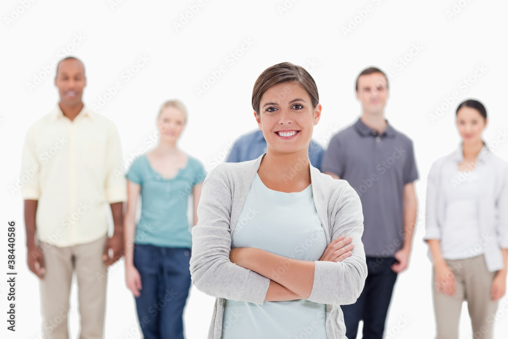 Close-up of a woman smiling and crossing her arms with people be