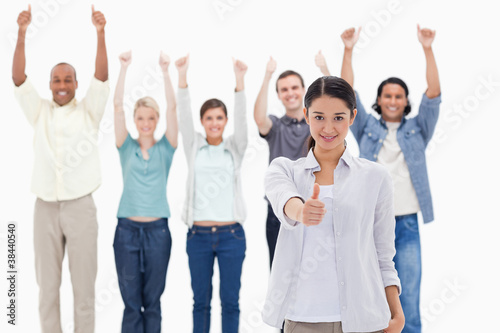 Close-up of a girl with people raising their arms and with their
