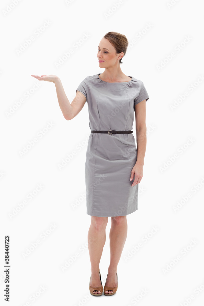 Woman in a dress presenting something with her hand Woman in a dress presenting something with her hand