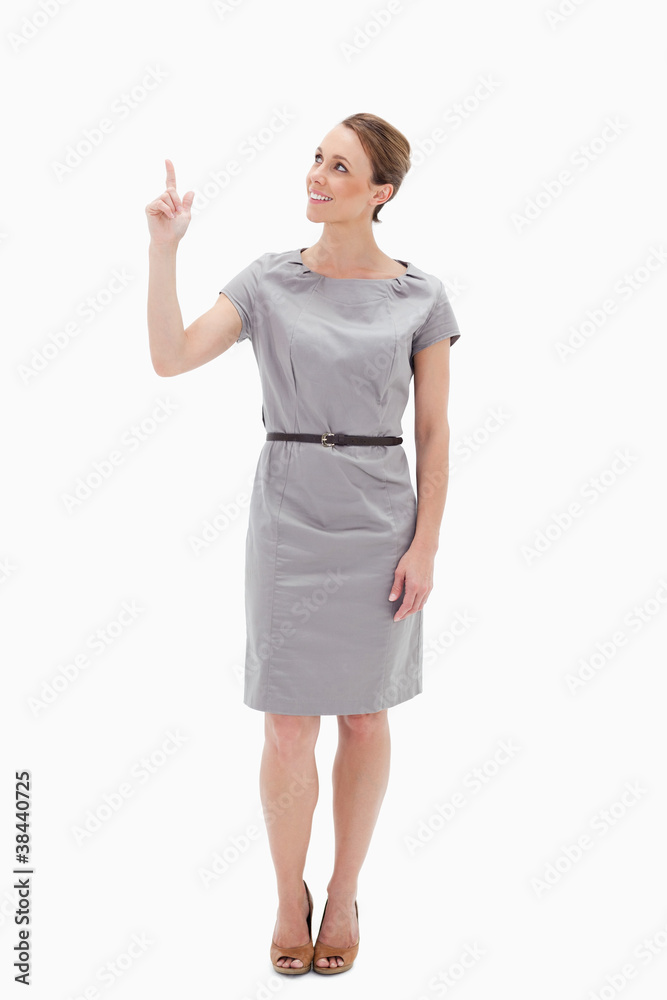 Smiling woman in dress showing something above with her hand Smiling woman in dress showing something above with her hand