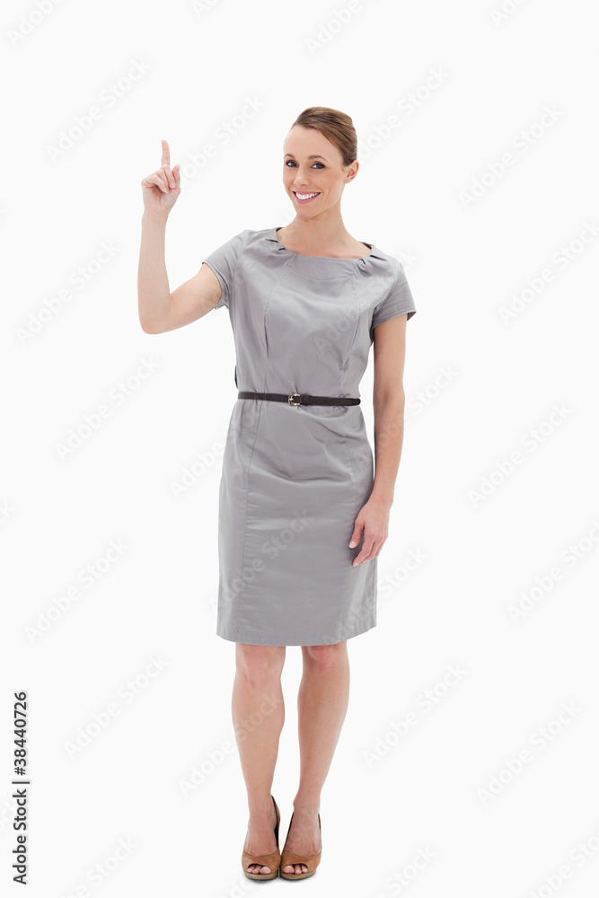 Woman posing in a dress showing something above with her hand Woman posing in a dress showing something above with her hand