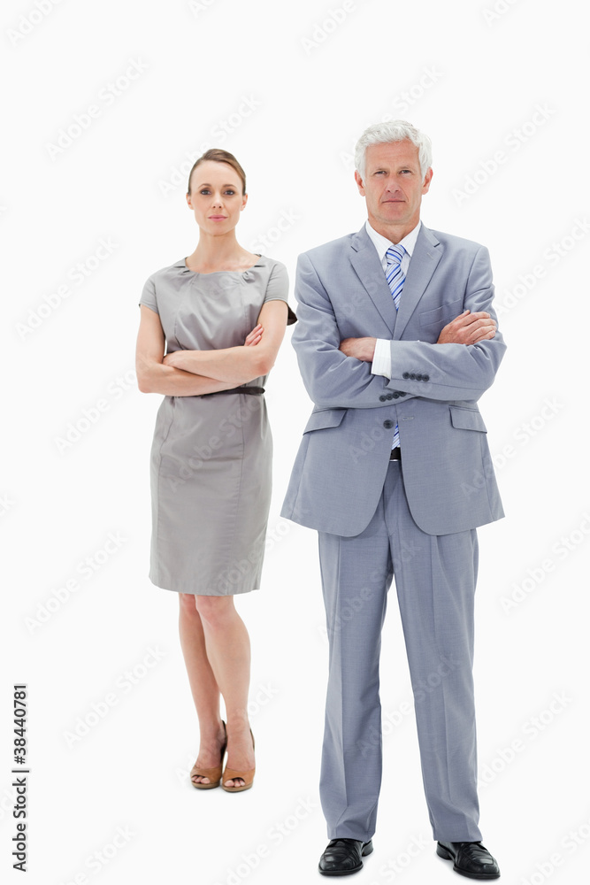 White hair businessman with a woman behind him crossing their ar White hair businessman with a woman behind him crossing their ar
