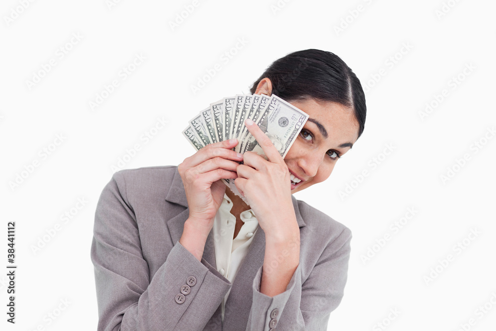 Young saleswoman covering her face with bank notes Young saleswoman covering her face with bank notes