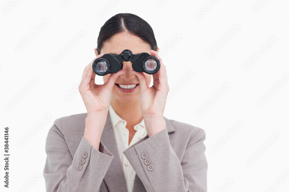 Smiling businesswoman looking through spy glasses Smiling businesswoman looking through spy glasses