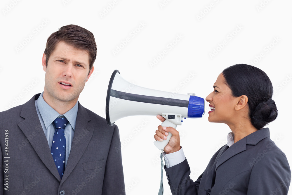 Close up of saleswoman with megaphone yelling at colleague Close up of saleswoman with megaphone yelling at colleague