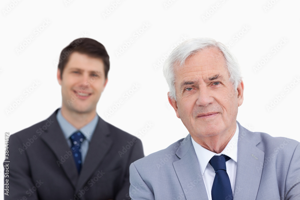 Close up of mature businessman with colleague behind him Close up of mature businessman with colleague behind him