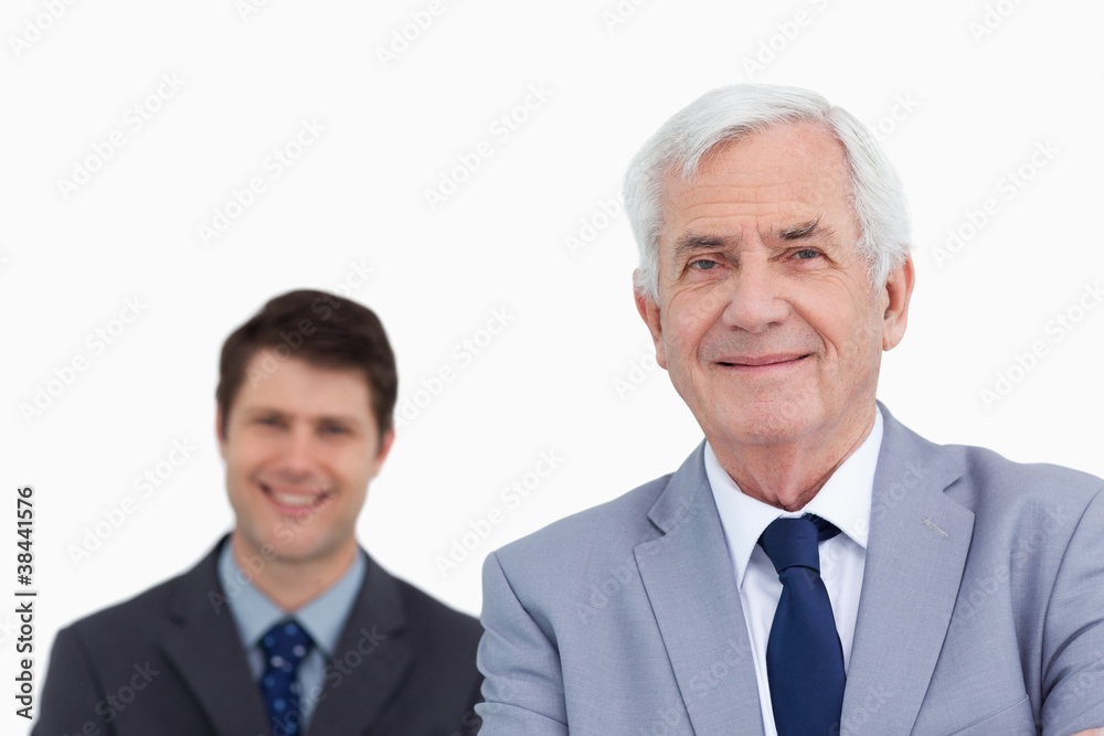 Close up of mature businessman with employee behind him Close up of mature businessman with employee behind him