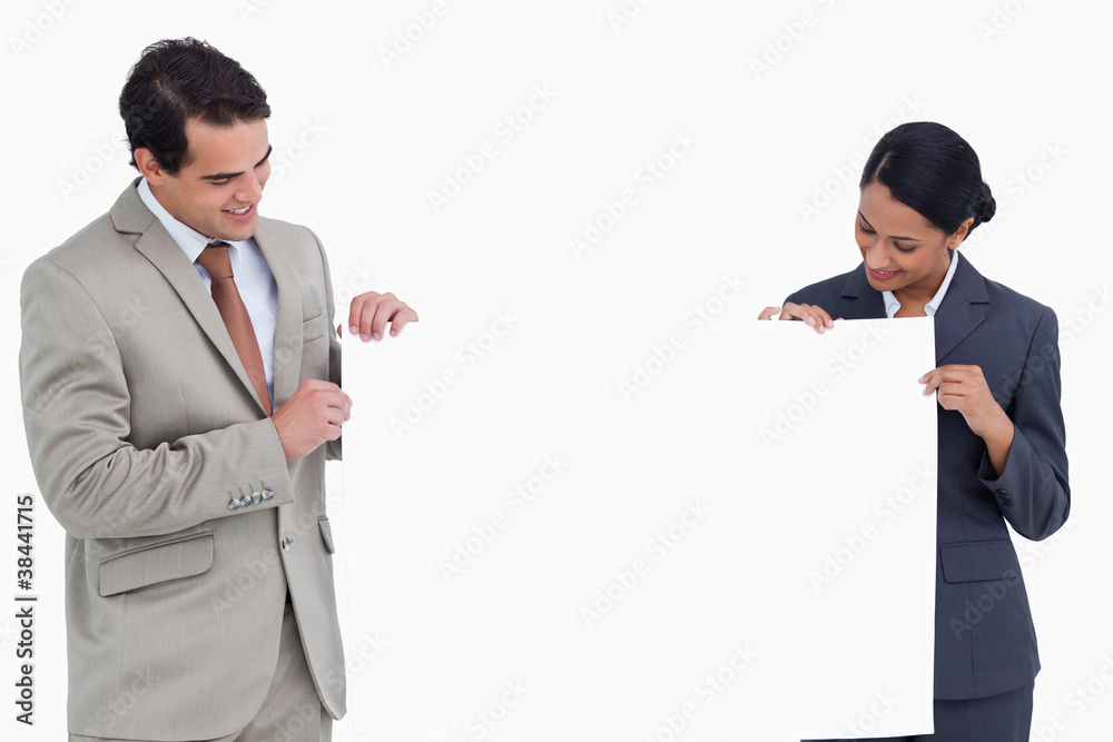 Salesteam holding and looking at blank sign Salesteam holding and looking at blank sign