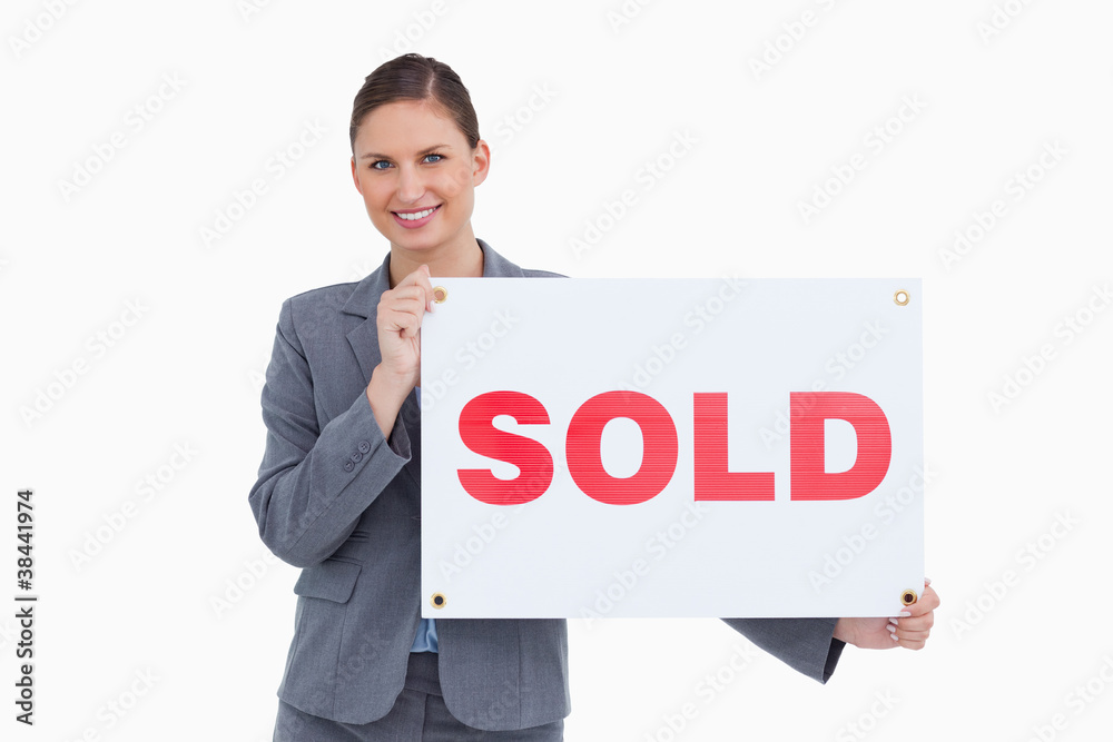 Smiling real estate agent holding sold sign Smiling real estate agent holding sold sign