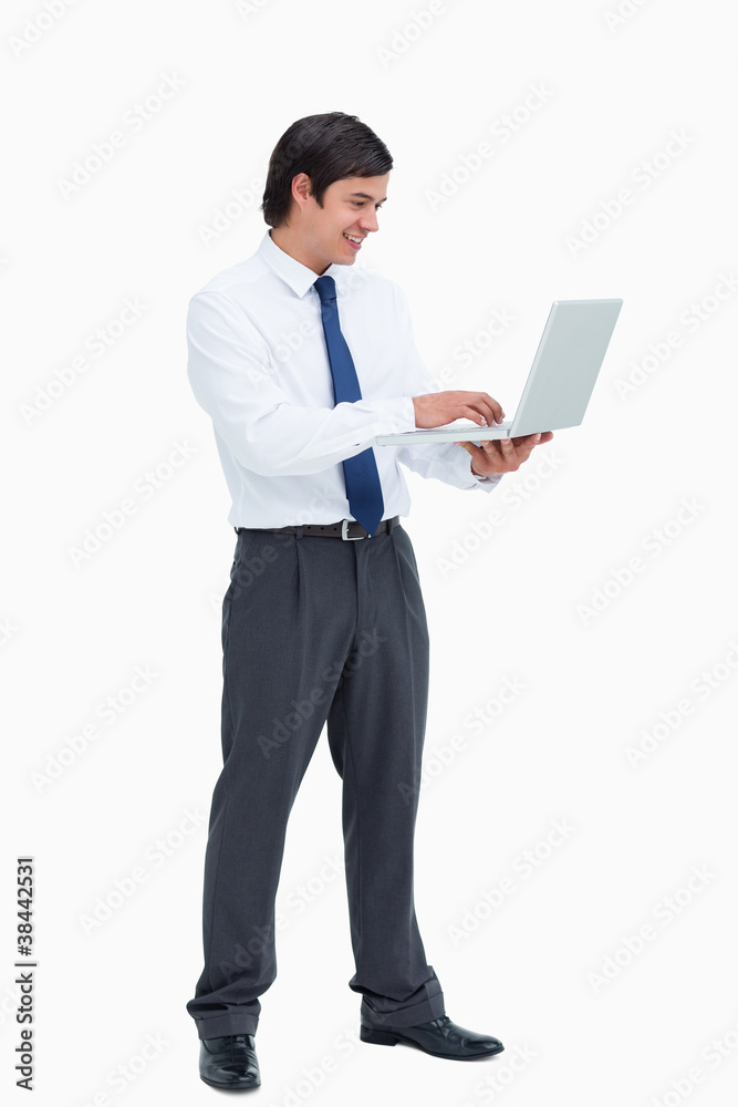 Side view of smiling tradesman working on his laptop