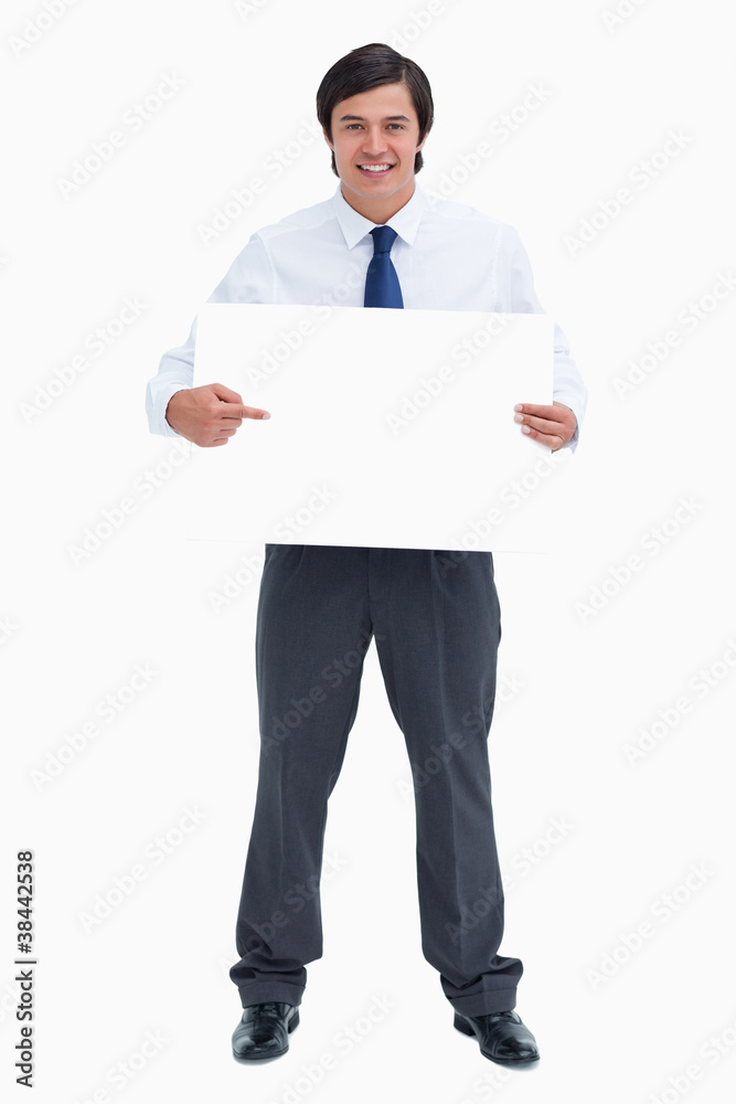 Smiling tradesman pointing at blank sign in his hands Smiling tradesman pointing at blank sign in his hands