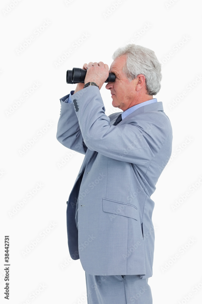 Side view of mature tradesman looking through spy glass Side view of mature tradesman looking through spy glass