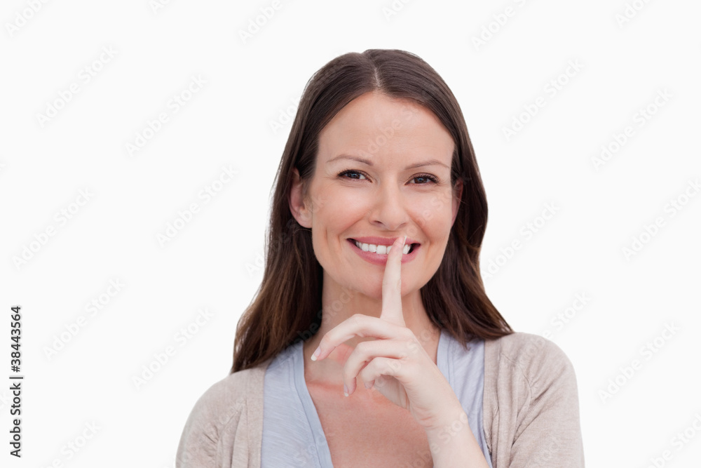 Close up of smiling woman asking for silence Close up of smiling woman asking for silence
