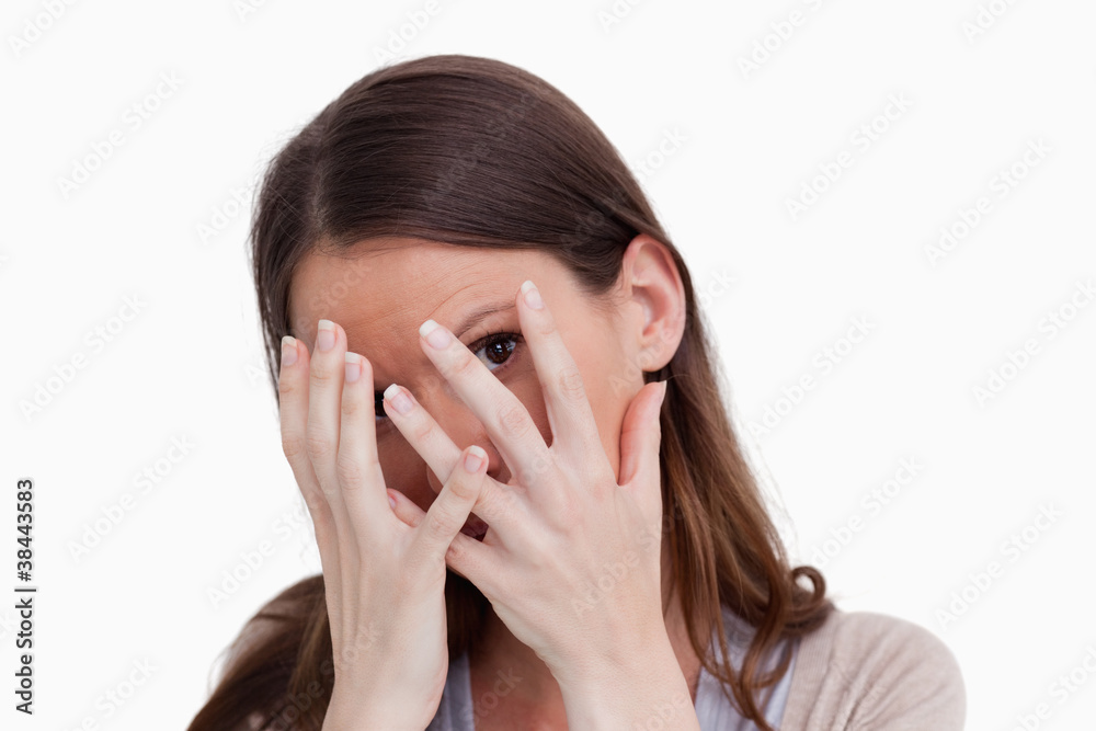Close up of woman hiding behind her hands