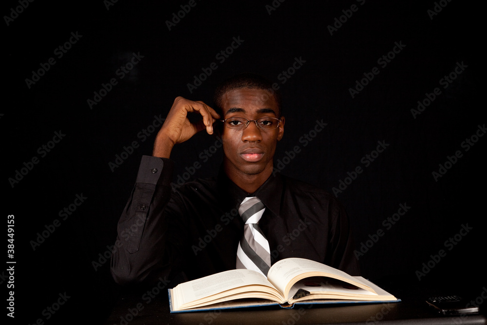 Handsome black man studying from a book and thinking Handsome black man studying from a book and thinking