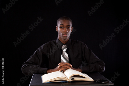 Handsome black man studying from a book photo