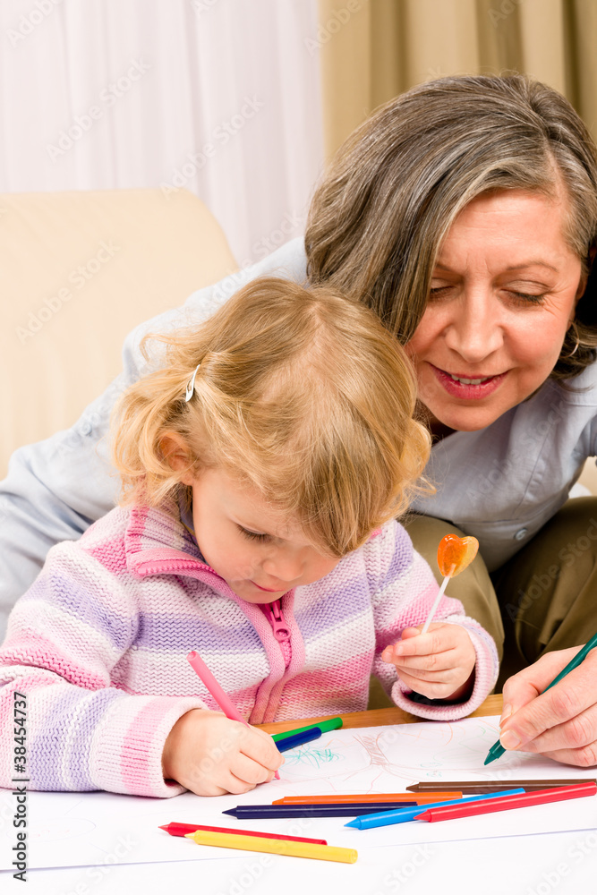 Cute little girl drawing with grandmother at home Cute little girl drawing with grandmother at home