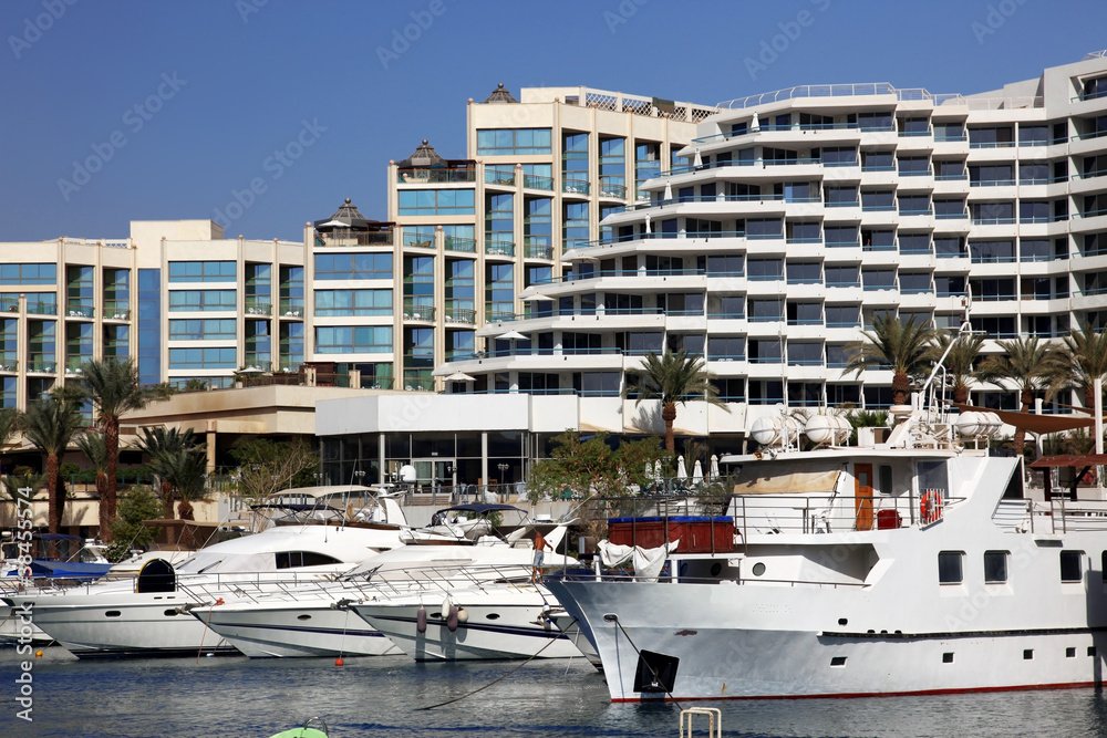 Luxury Yachts Docked In Front Of Waterfront Hotels