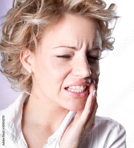 Young woman in pain is having toothache