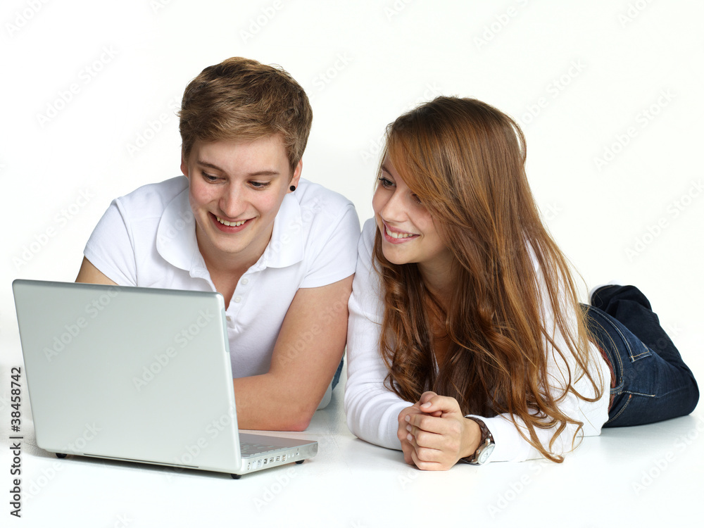 Young couple lying on the floor surfing on the internet Young couple lying on the floor surfing on the internet
