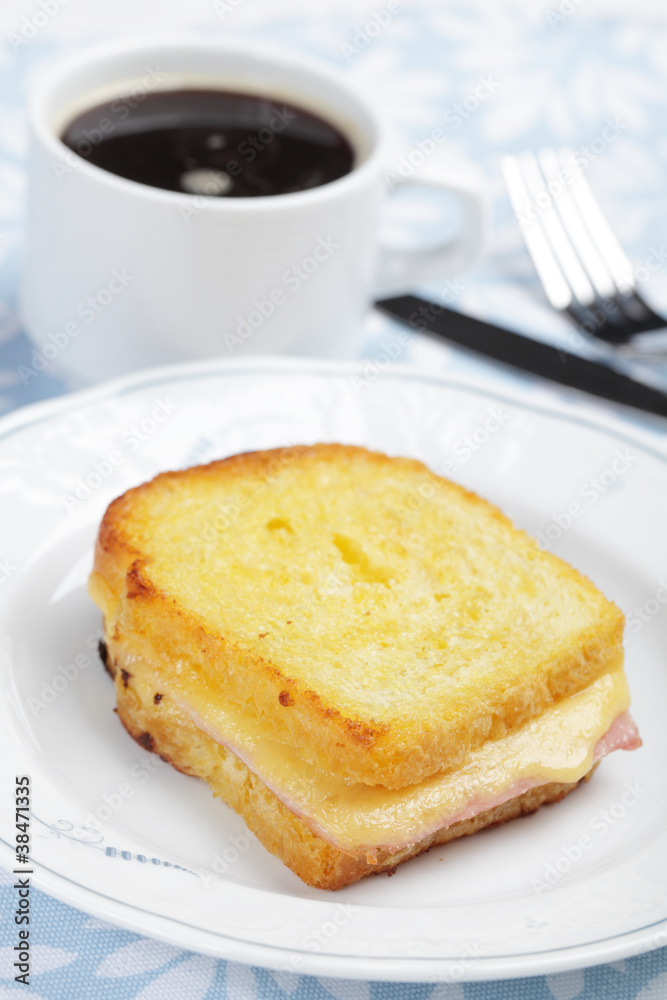 Croque-monsieur sandwich and a cup of black coffee