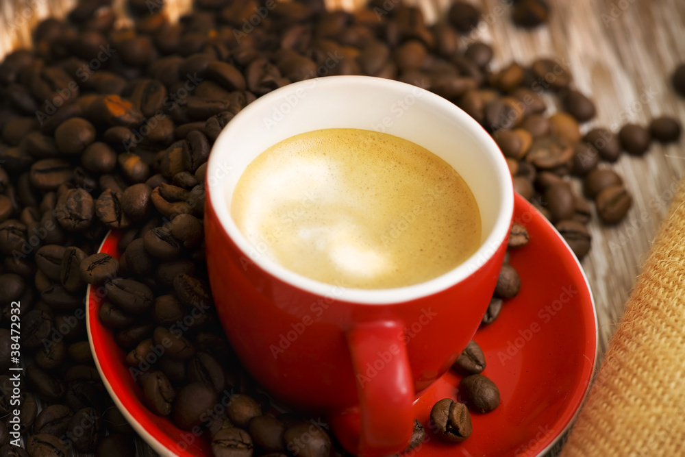 Obraz premium Caffè in tazza rossa e chicchi