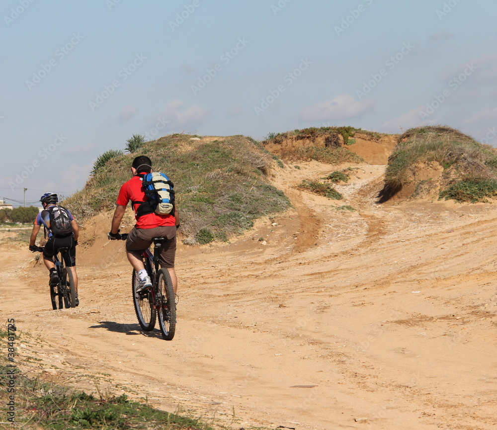 Young men are riding on mountain bicycles Young men are riding on mountain bicycles