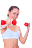 Smiling woman with barbells, focus is on the nearest barbell