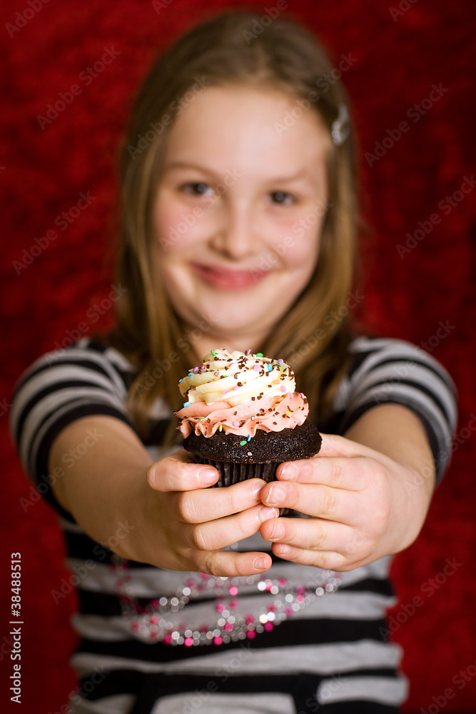 young girl eating a delicious cupcake