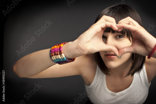 Beautiful girl forming heart with her hands