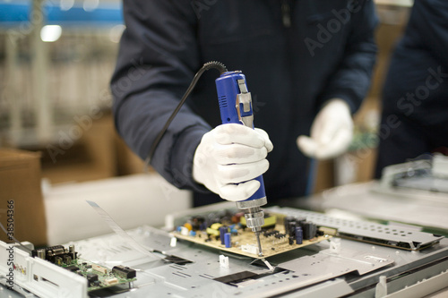 Close up of technician working on electronics photo