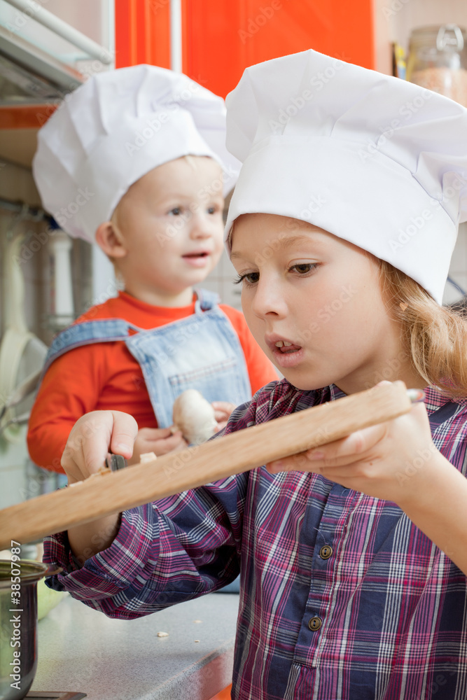 girl in a cook cap helps to make a dinner. girl in a cook cap helps to make a dinner.