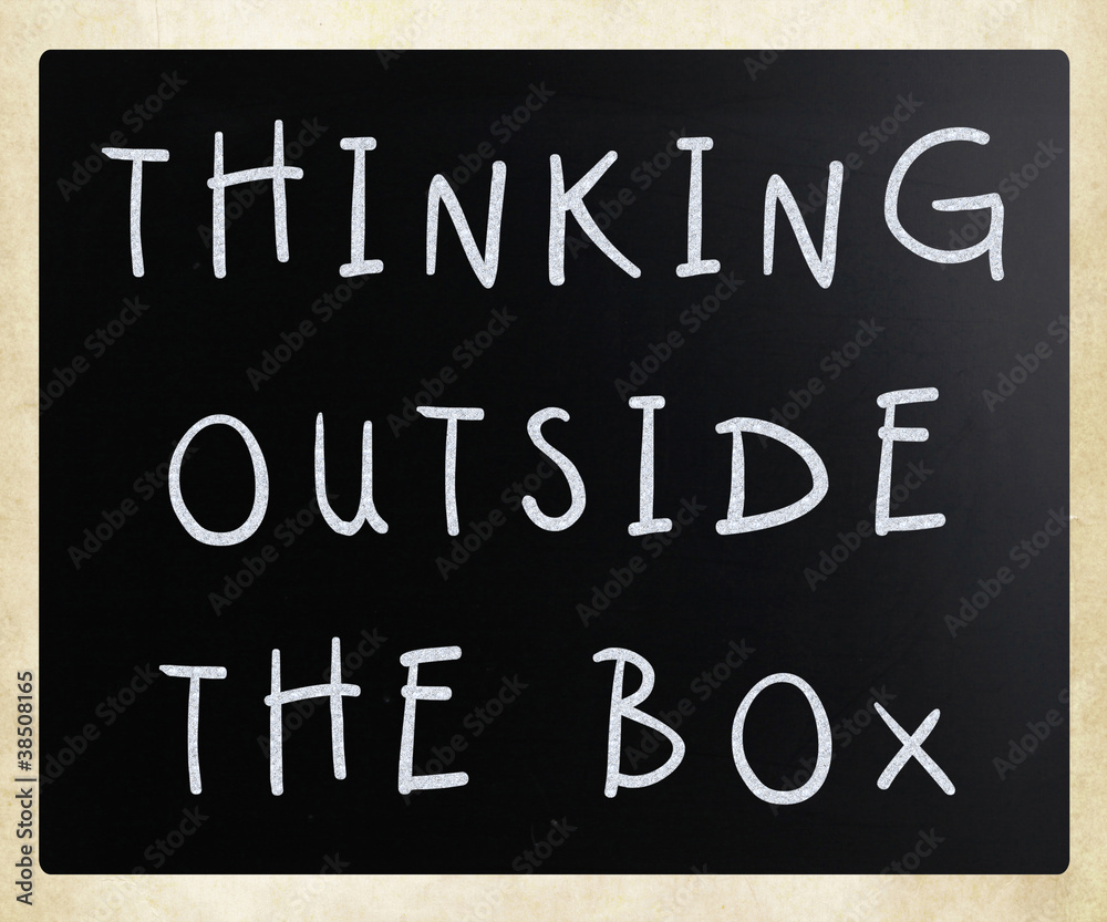 Thinking outside the box phrase, handwritten with white chalk on Thinking outside the box phrase, handwritten with white chalk on