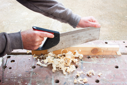 Obraz na plátne carpenter sawing wood